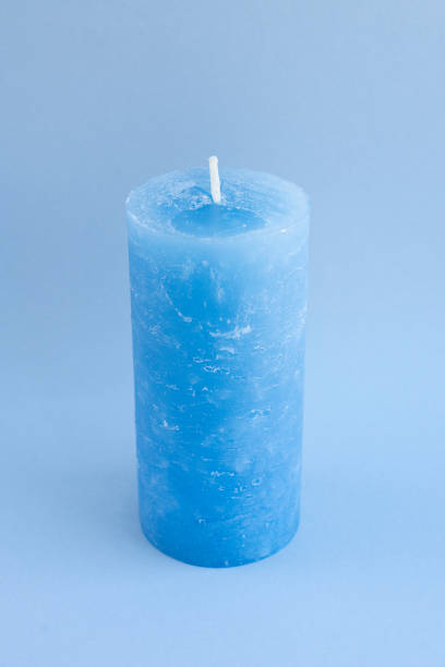 istock One big blue new wax candle for interior design on blue background. Minimalistic and beautiful accessories. Idea for cold winter gift and decorating home, cafe, shop. Relax and meditation atmosphere 1434180894