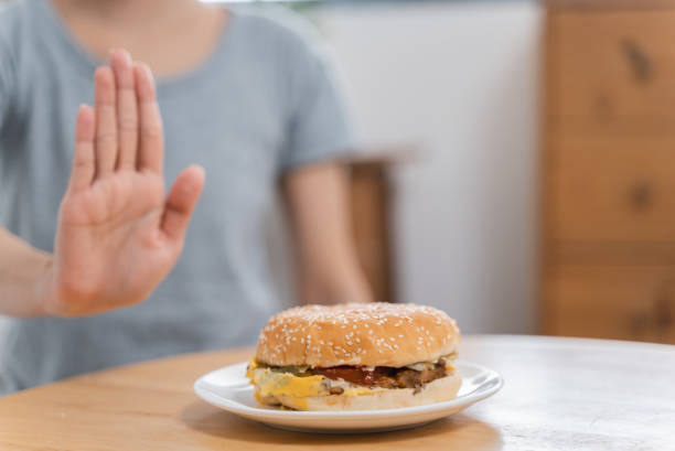 istock Unrecognize woman making hand sign to refuse hamburger on the table 1434182955