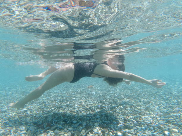 istock Young woman swimming underwater 1434185617