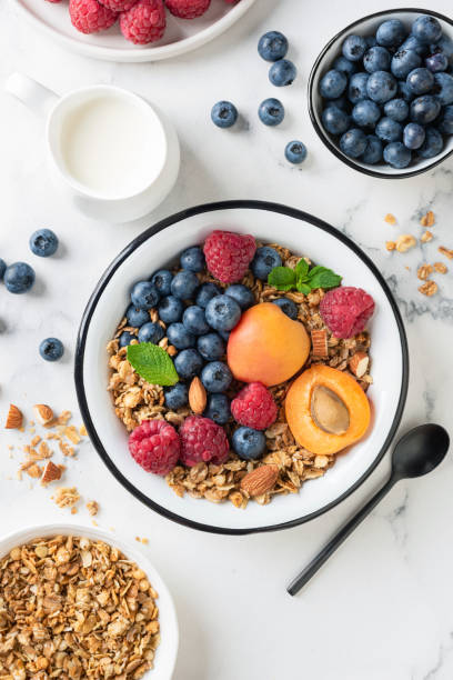 Breakfast granola bowl with berries, fruits and almond milk stock photo