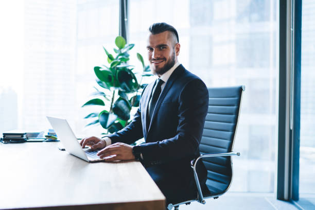 istock Smiling boss working near window in office 1434193087