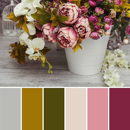 Paper and textile artificial flowers in a decorative bouquet. The interior decoration of a photo studio is shot in natural light during the day. Autumn colors. Color palette for design.