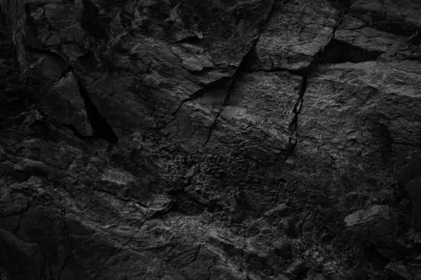 Photo of Black white rock texture with cracks. Rough surface mountain surface. Close-up. Stone granite background.