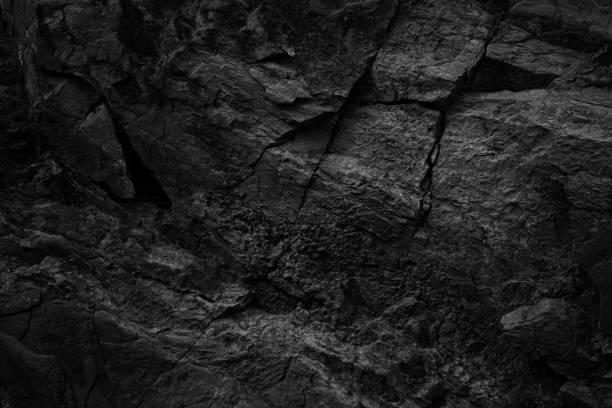 черно-белая текстура скалы с трещинами. шероховатая поверхность горной поверхности. кр�упный план. каменный гранитный фон. - volcanic stone стоковые фото и изображения