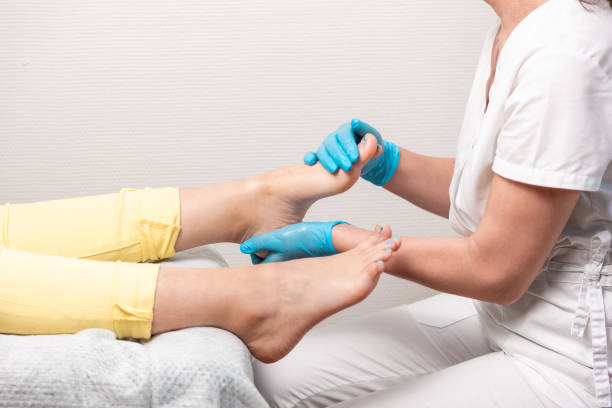 a pedicurist massages the client's feet. close-up of legs and toenails with titanium thread and master's arms. the concept of chiropody and podology - podiatrist customer service beauty spa imagens e fotografias de stock