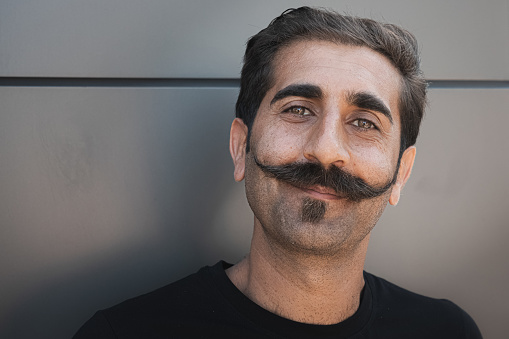 Close-up street portrait of a Turkish man with a very distinctive and stylised moustache.