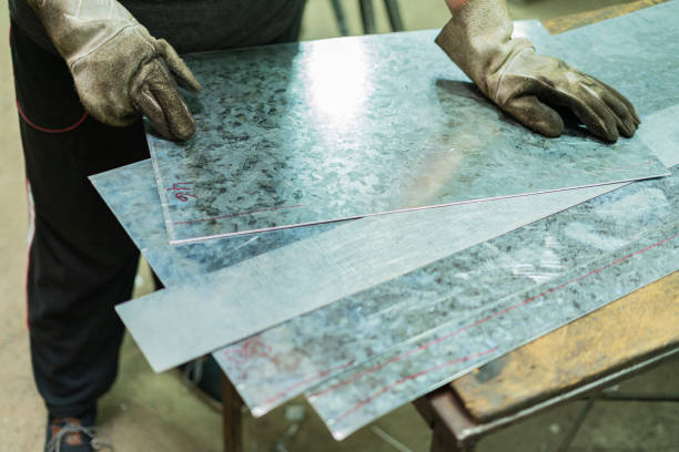 Latino man with an average age of 20 dressed casually Employees of a locksmith are working together cutting metal material