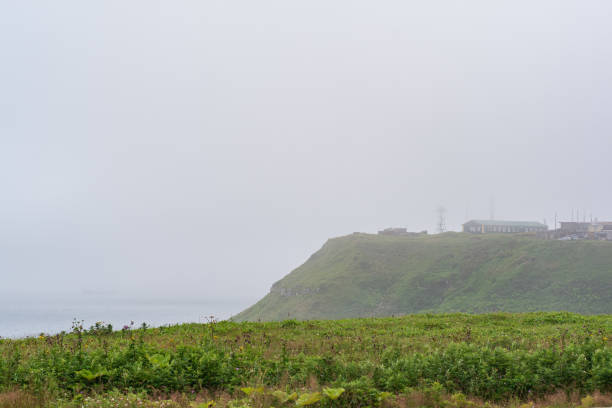 暗い海に通信ポイントを持つ霧の岬 - kunashir island audio ストックフォトと画像