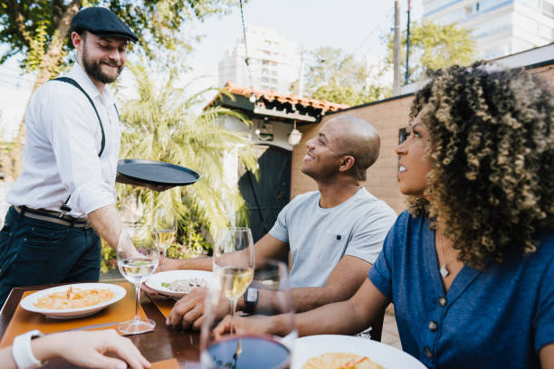 istock Waiter serving food at restaurant table to customers 1434202611