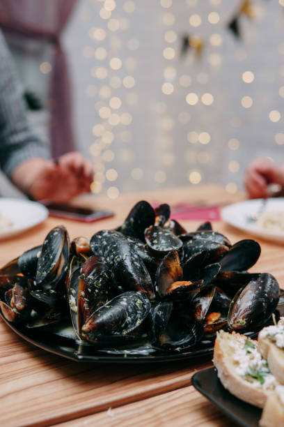 istock Raw mussels on a black plate at a cooking class. Master class on seafood. Cooking mussels. 1434203314