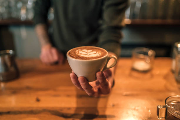 Barista holding a cup of espresso coffee stock photo