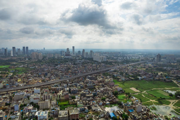 istock aerial drone shot over gurgaon showing monsoon clouds with light rays falling on ground crowded with homes houses, sohna highway feilds and water pools around under construction buildings 1434203361