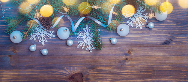 Flat lay christmas composition with fir branches and christmas ball, garland on a wooden table. Winter holiday background with copy space