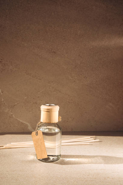 istock Aroma diffuser in a clear glass bottle with a wooden cap on a light stone background with wooden sticks behind 1434204580