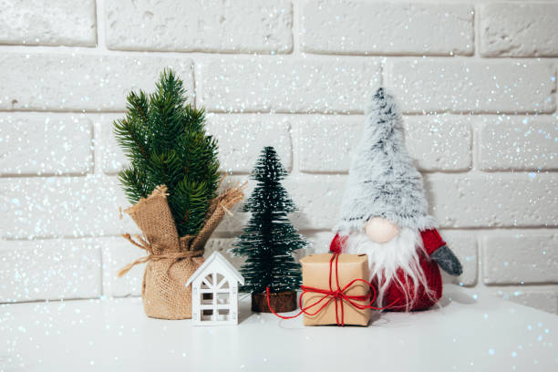 istock New Year, Christmas background with lights. New Year's decor on a white table with gnomes, gift, white house 1434204633