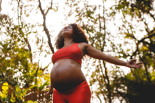 A pregnant woman sitting outdoor during sunset beautiful outdoor.. Maternity.