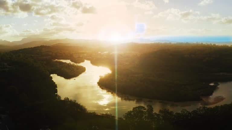 Amazon forest and sky drone with sunset flare on river in peaceful rainforest nature environment. Aerial view of tropical jungle landscape and ecosystem in ecuador with dreamy evening clouds.