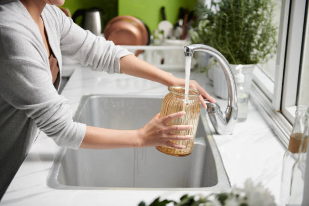 Woman Filling Vase with Water stock photo