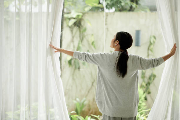 istock Woman Opening Curtains 1434207325