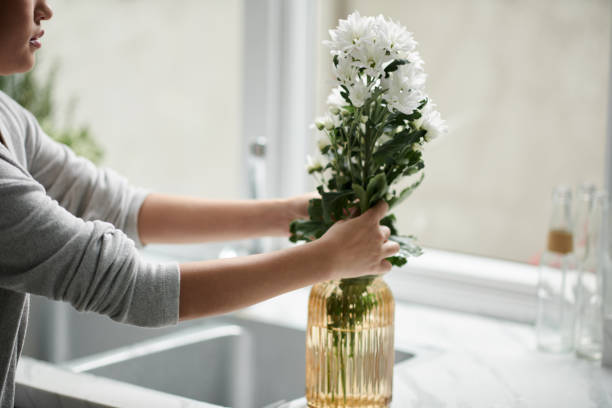 istock Woman Putting Flowers in Vase 1434207326