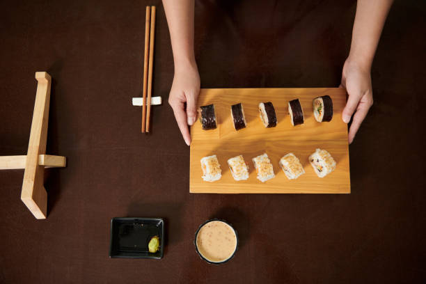 istock Woman Holding Bamboo Sushi Board 1434207855