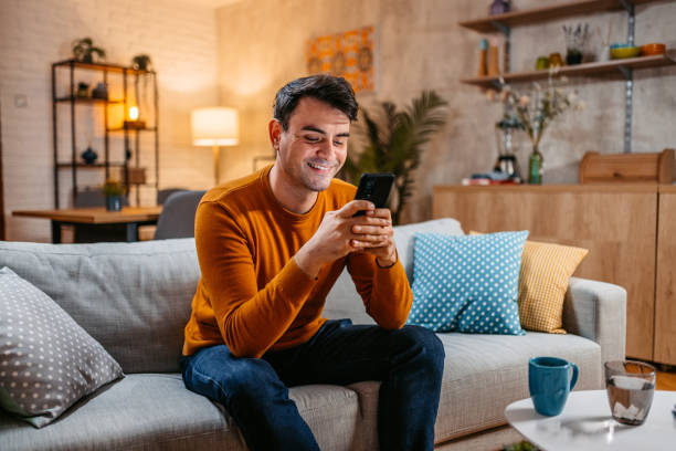 istock Young Man Texting On The Phone At Home 1434207995