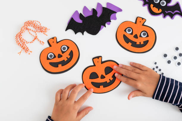 istock child making felt pumpkins and bats sitting at table 1434210212