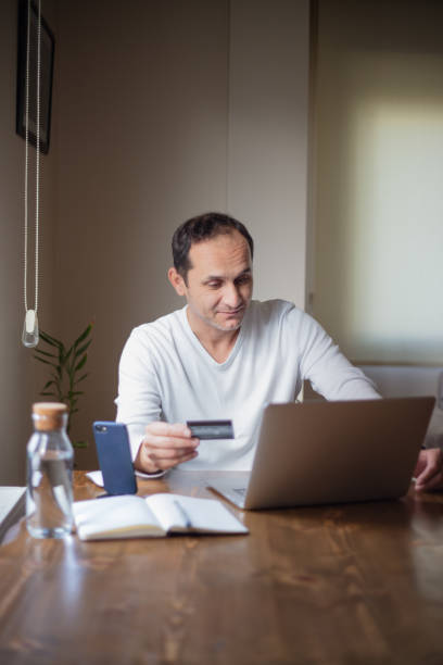 istock Man working at home and making transactions with his credit card. 1434211033