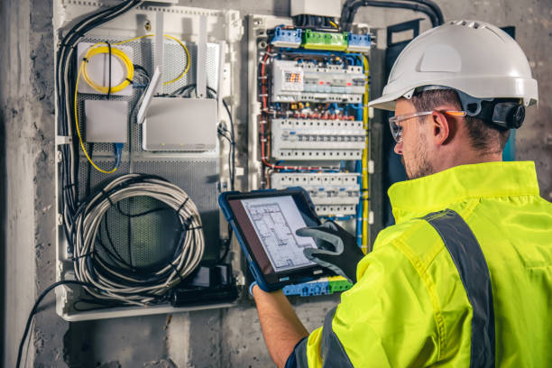 istock Man, an electrical technician working in a switchboard with fuses, uses a tablet. 1434211820