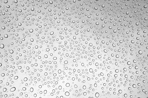 Close-up of water drops on silver surface, wet background