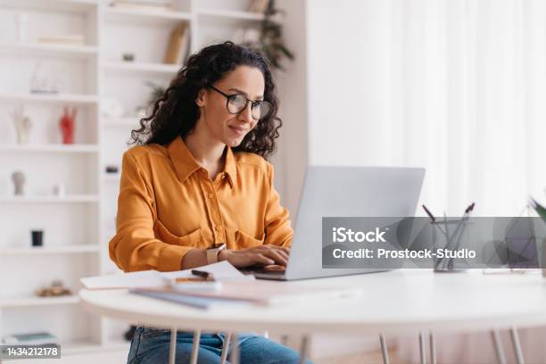 Middle Eastern Lady Using Laptop Working Online Sitting In Office Stock Photo - Download Image Now