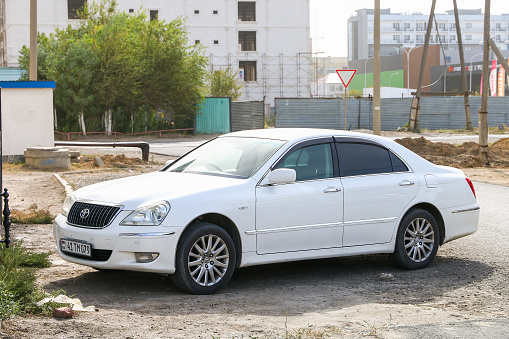 Atyrau, Kazakhstan - October 3, 2022: White luxury car Toyota Crown Majesta (S180) in the city street.