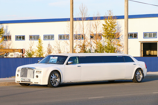 Atyrau, Kazakhstan - October 8, 2022: White limousine Chrysler 300C in the city street.