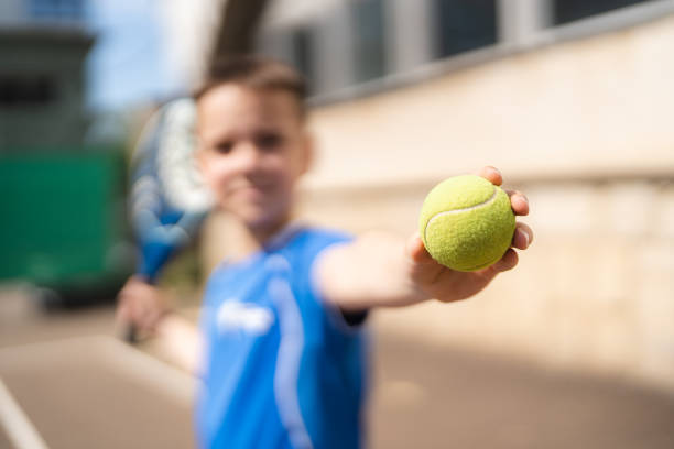 Boy play padel on outdoor tennis court stock photo