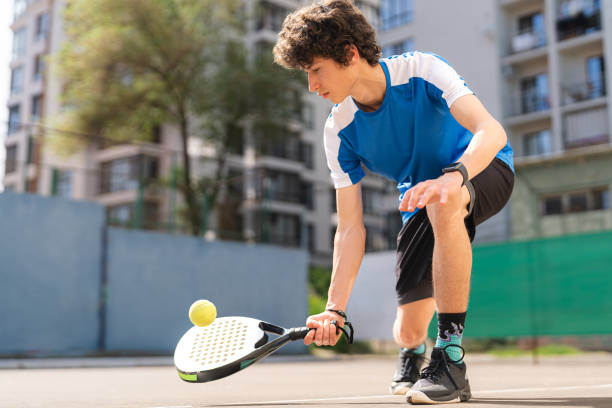 Boy play padel on outdoor tennis court stock photo