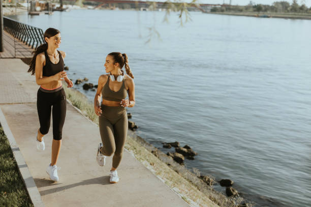 istock Young woman taking running exercise by the river promenade 1434218042