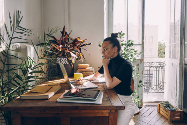 istock Confident young woman using laptop while sitting at her working place in office 1434218214