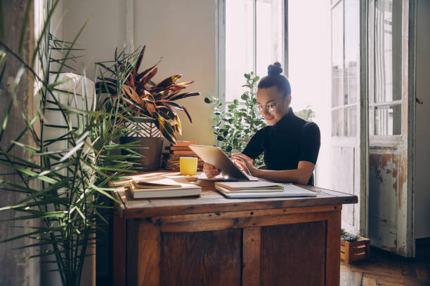 istock Confident young woman using digital tablet while sitting at her working place in office 1434218654