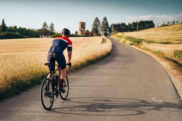 vue arrière d'un cycliste dans la campagne - racing bicycle cycling professional sport bicycle photos et images de collection