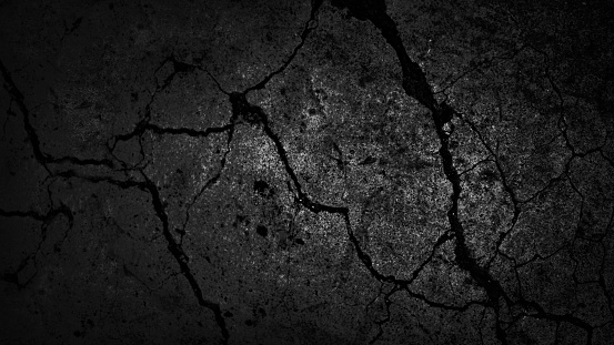 Black white old wall texture. Cracked rough concrete plate. Close-up. Dark gray grunge background for design. Distressed, broken, damaged, crumbled surface. Spooky, creepy, horror concept. Halloween.