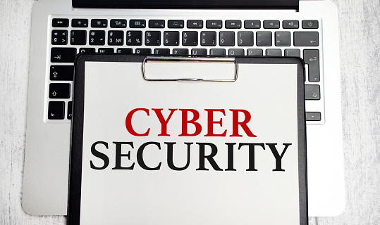 cyber security words on paper tablet and laptop