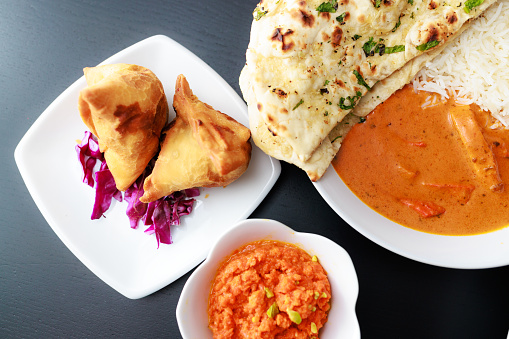 Indian food, Vegetable Samosas, Butter Chicken, Margh Makhani, Garlic Naan, Gajar Halwa\nShot with R5