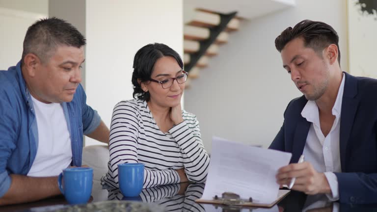 Financial advisor doing a meeting with a mid adult couple at home