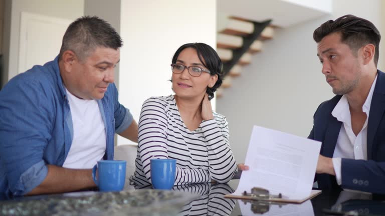 Financial advisor doing a meeting with a mid adult couple at home