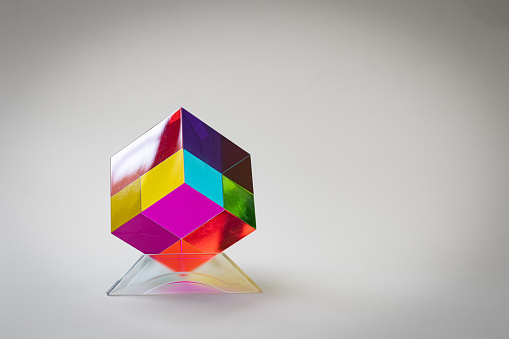 Transparent cube made out of acrylic plastic with translucent sides of different color. Colorful patterns projected to the observer depending on the point of view.