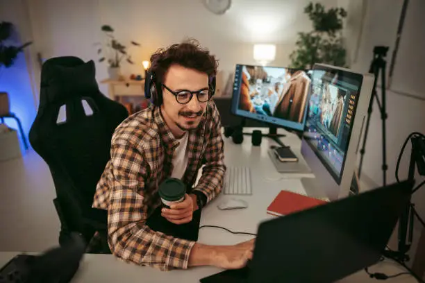 Photo of Young man editing video at the home office