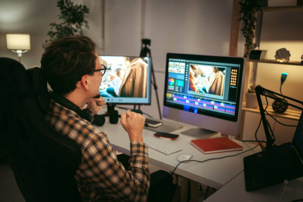 Male video editor working at home Young casually clothed editor working from home office setup photo editing screen stock pictures, royalty-free photos & images