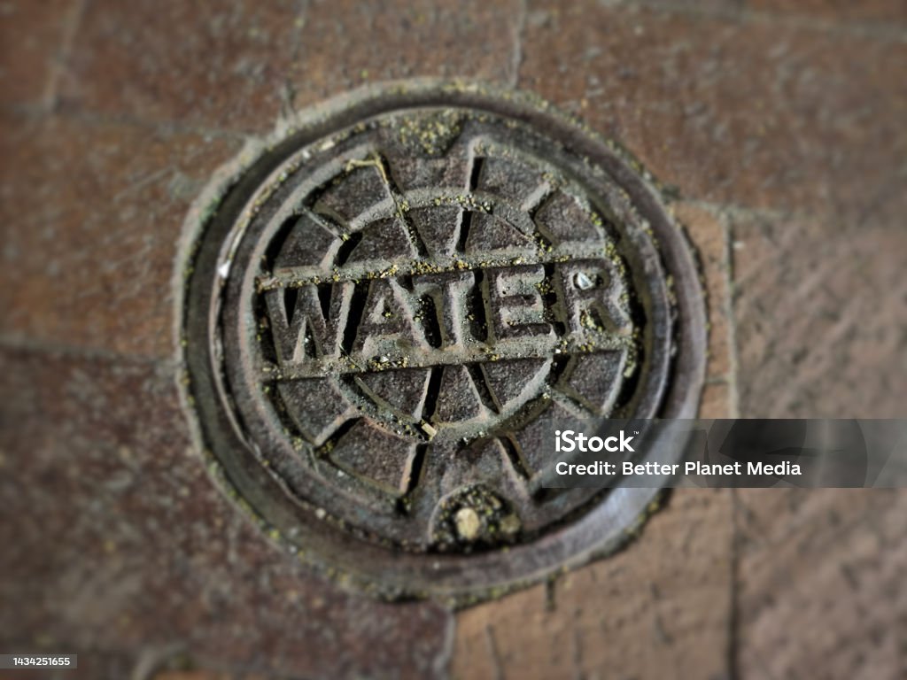 City Water Utility Cover Metal water utilities access cover. Brick Stock Photo