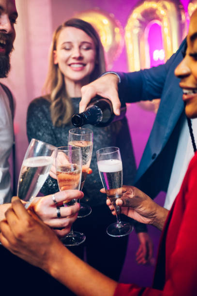 istock People hands holding flute glasses while pouring champagne 1434253176