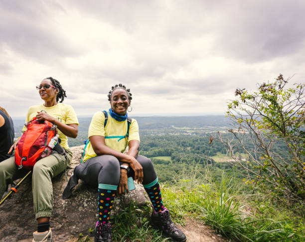 le donne si siedono per riposare durante la loro escursione - lookout mountaint foto e immagini stock